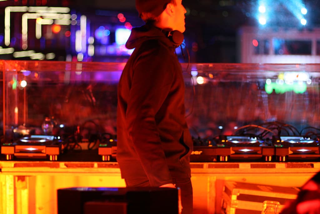 Festival-goers checking phones with ticket QR codes at the Igloofest gate under pier lights