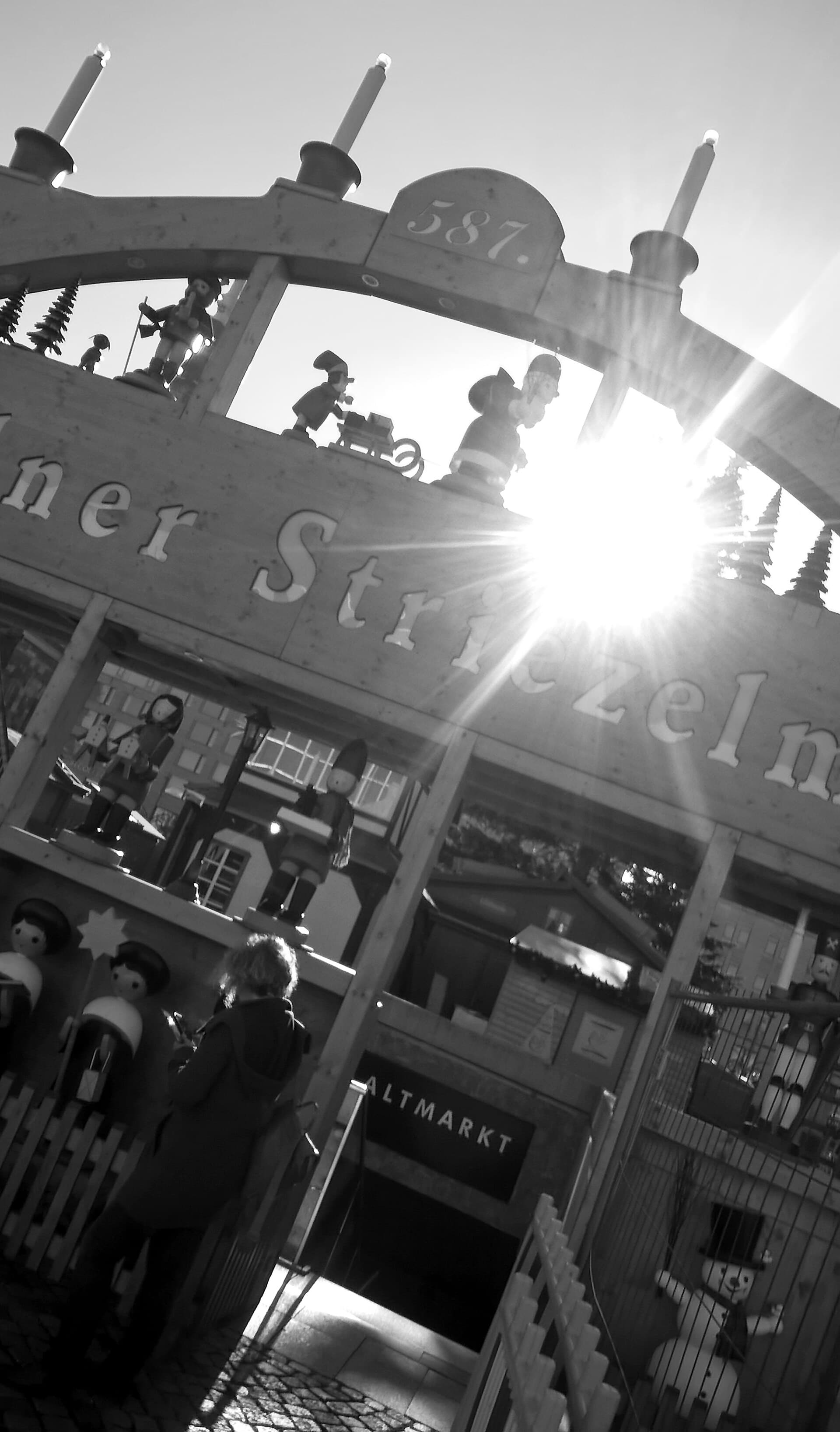 Visitors walking through the entrance arch at the Altmarkt on a weekday afternoon
