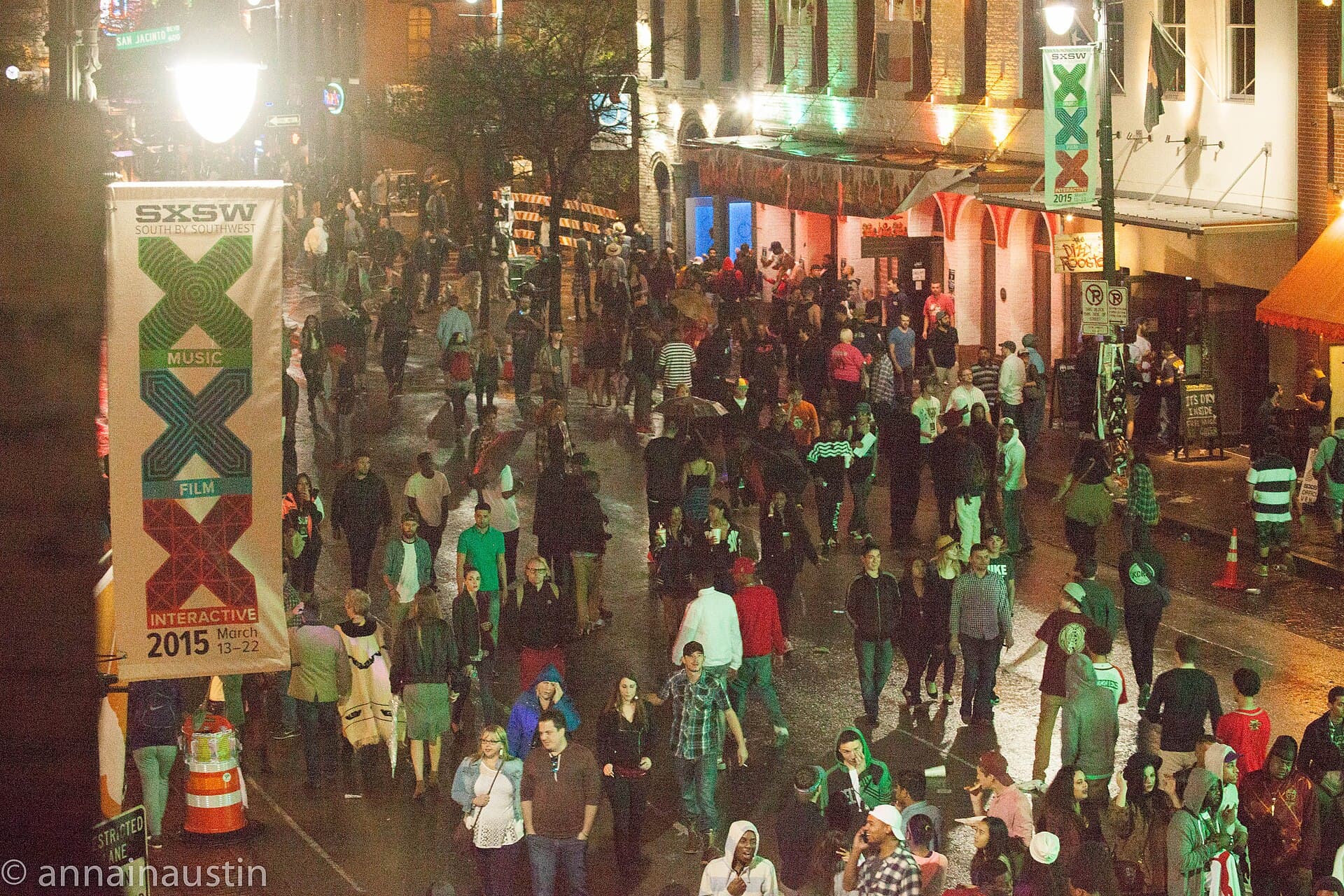 SXSW attendee wearing a lanyard badge outside a downtown Austin venue with a queue behind