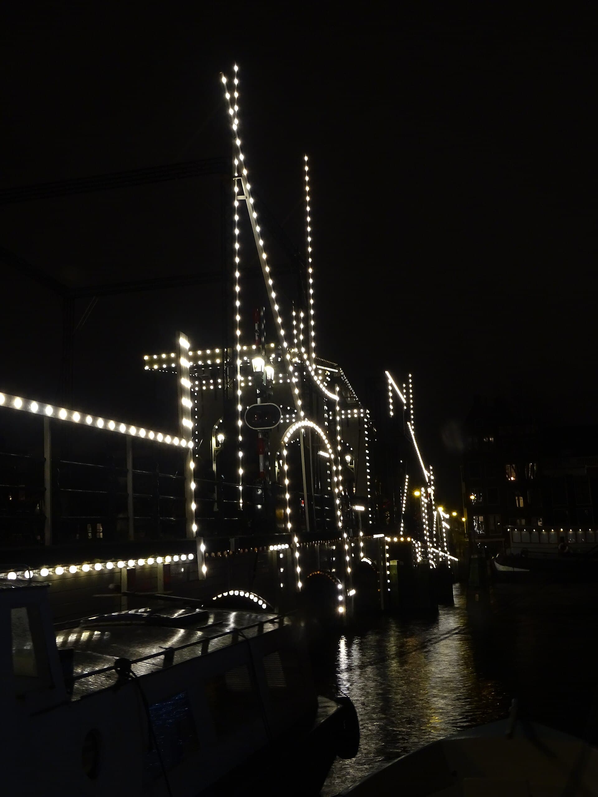 The Magere Brug lit up at night over the Amstel with a light installation in the water