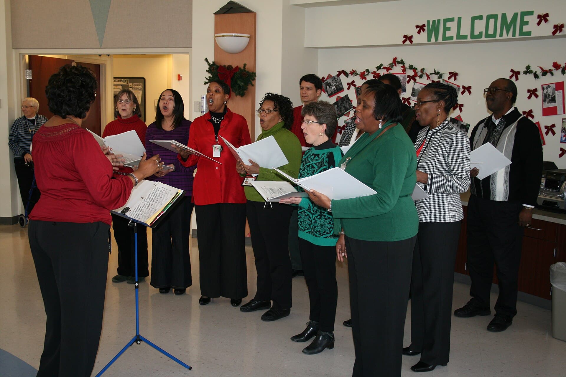 Carol singers performing on a stage with lit stalls and St. Mary's Basilica behind