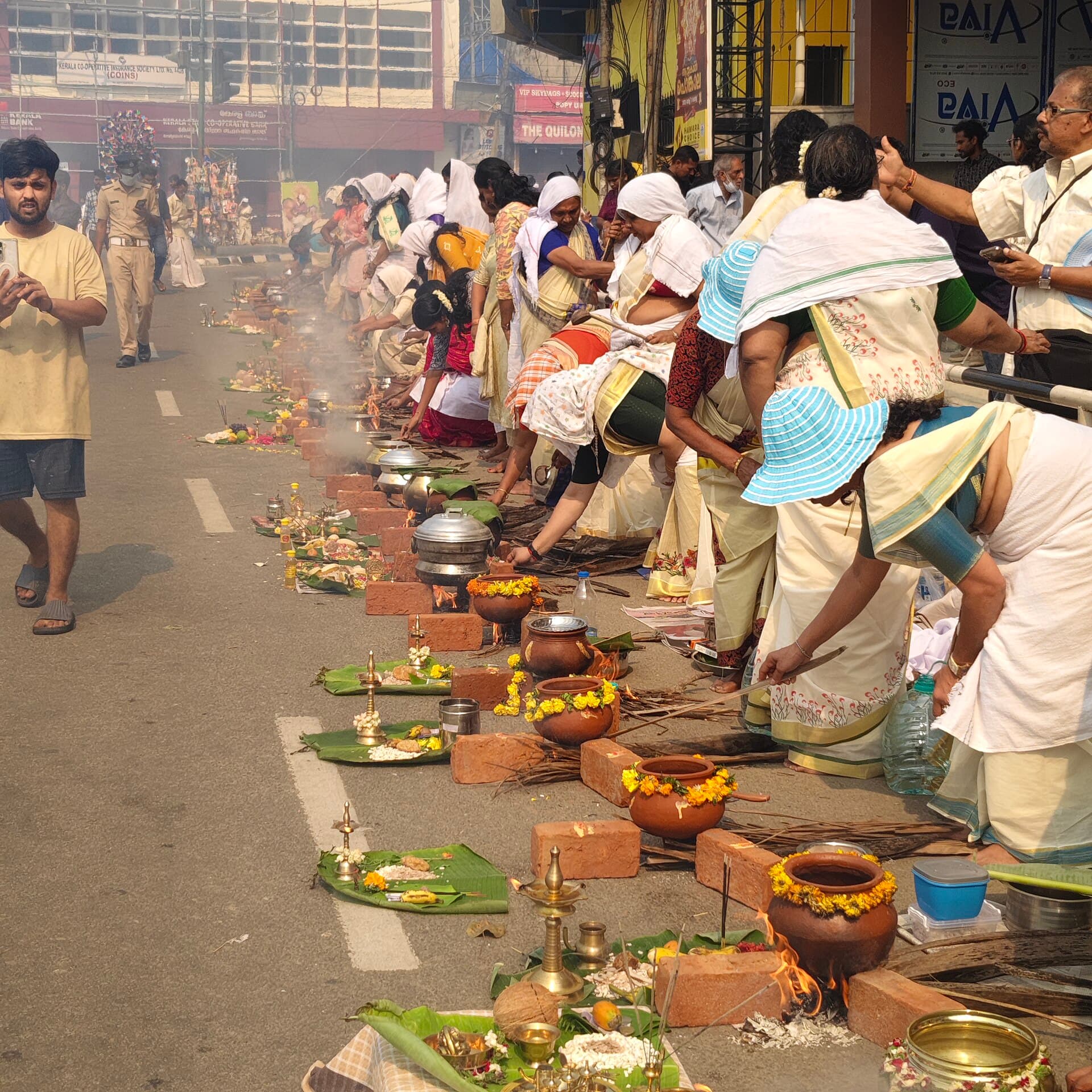 Smoke rising from hundreds of hearths along a Thiruvananthapuram street during Attukal Pongala
