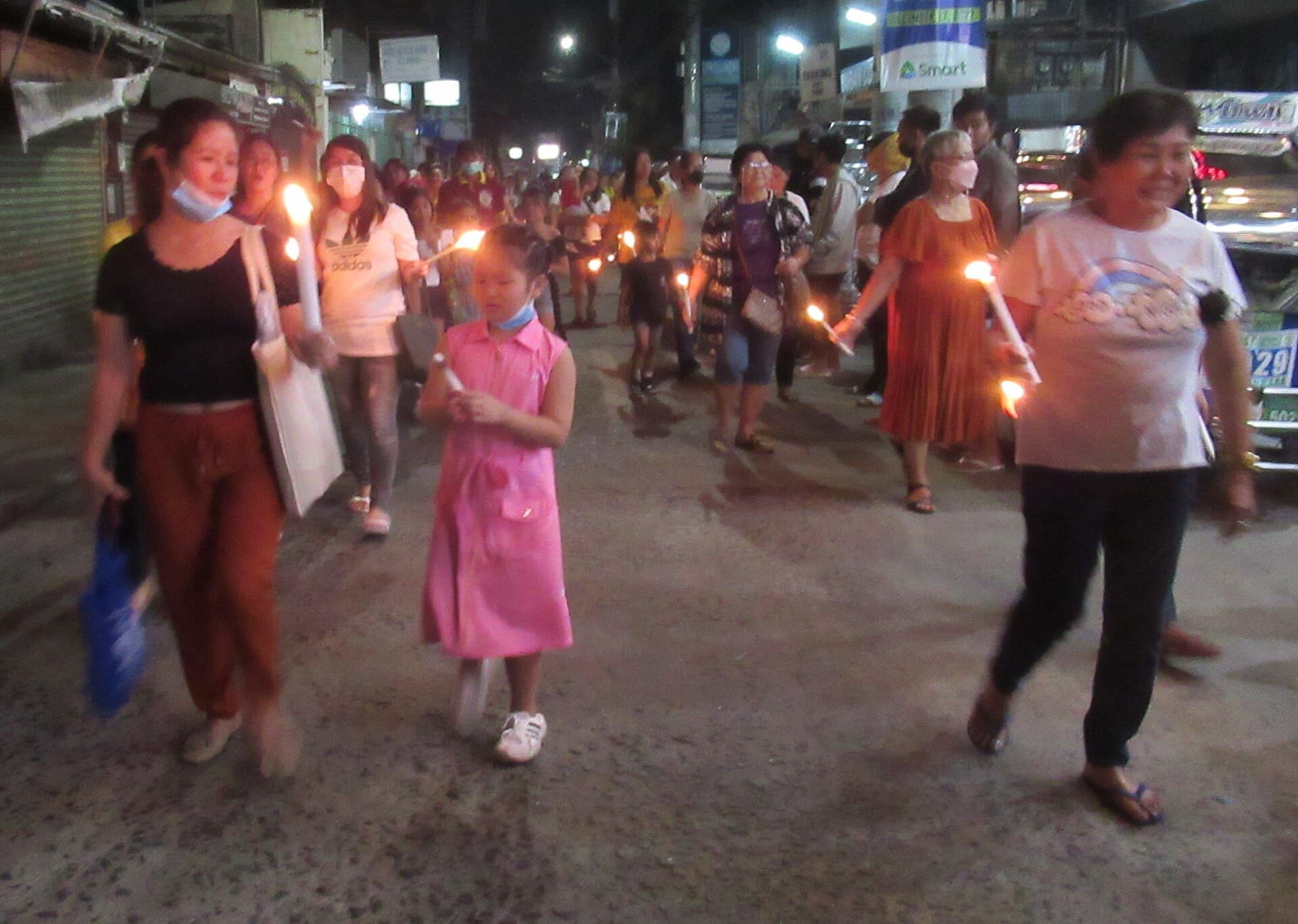 Devotees carrying Santo Niño images in procession outside Kalibo Cathedral