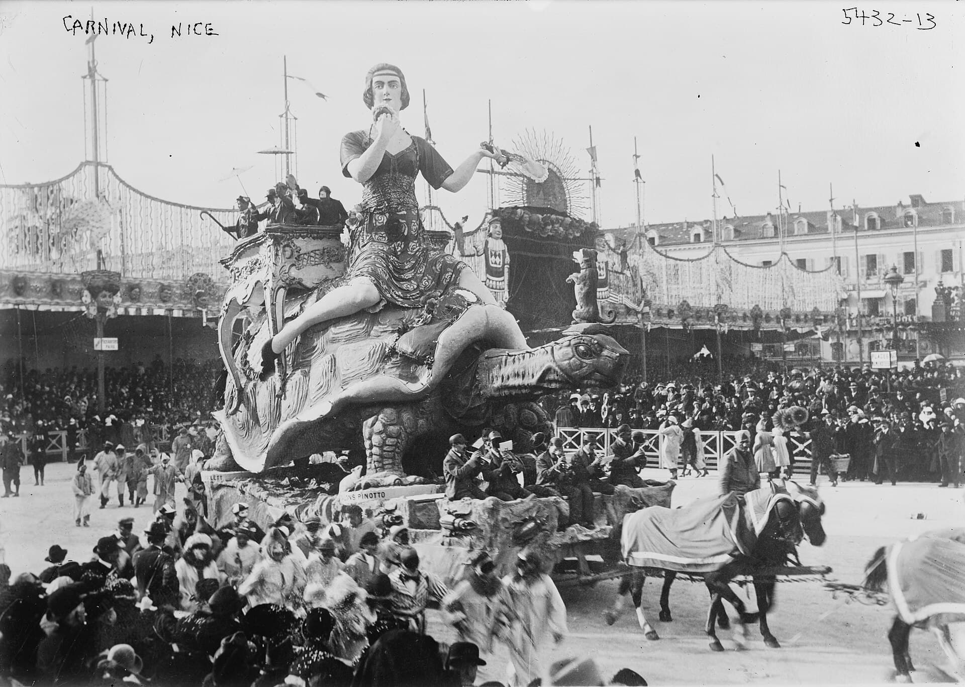 Giant carnival heads and floats parading in Nice during the daytime corso