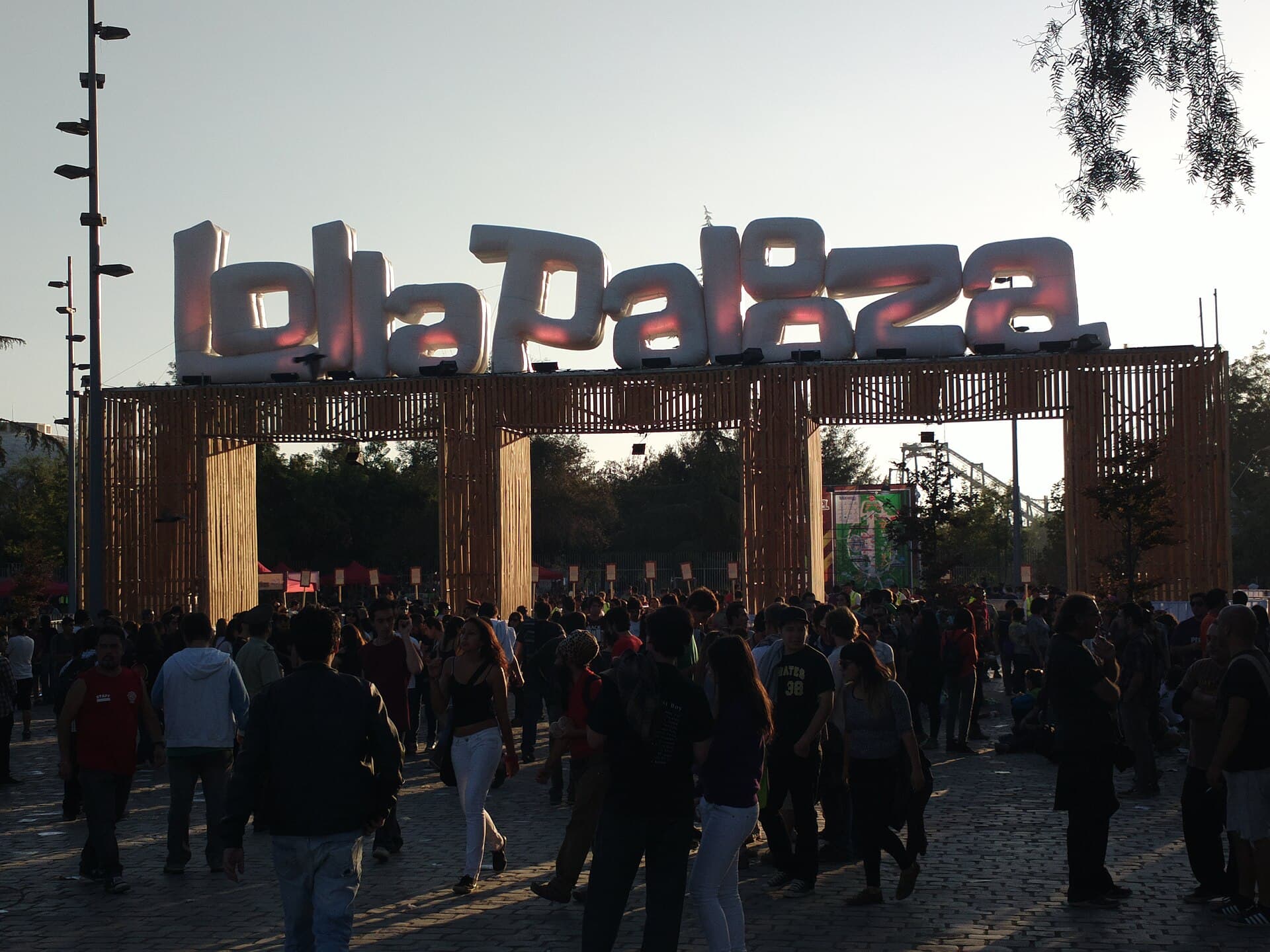 Wide shot of the main stage crowd at Parque O'Higgins at sunset with the Andes behind