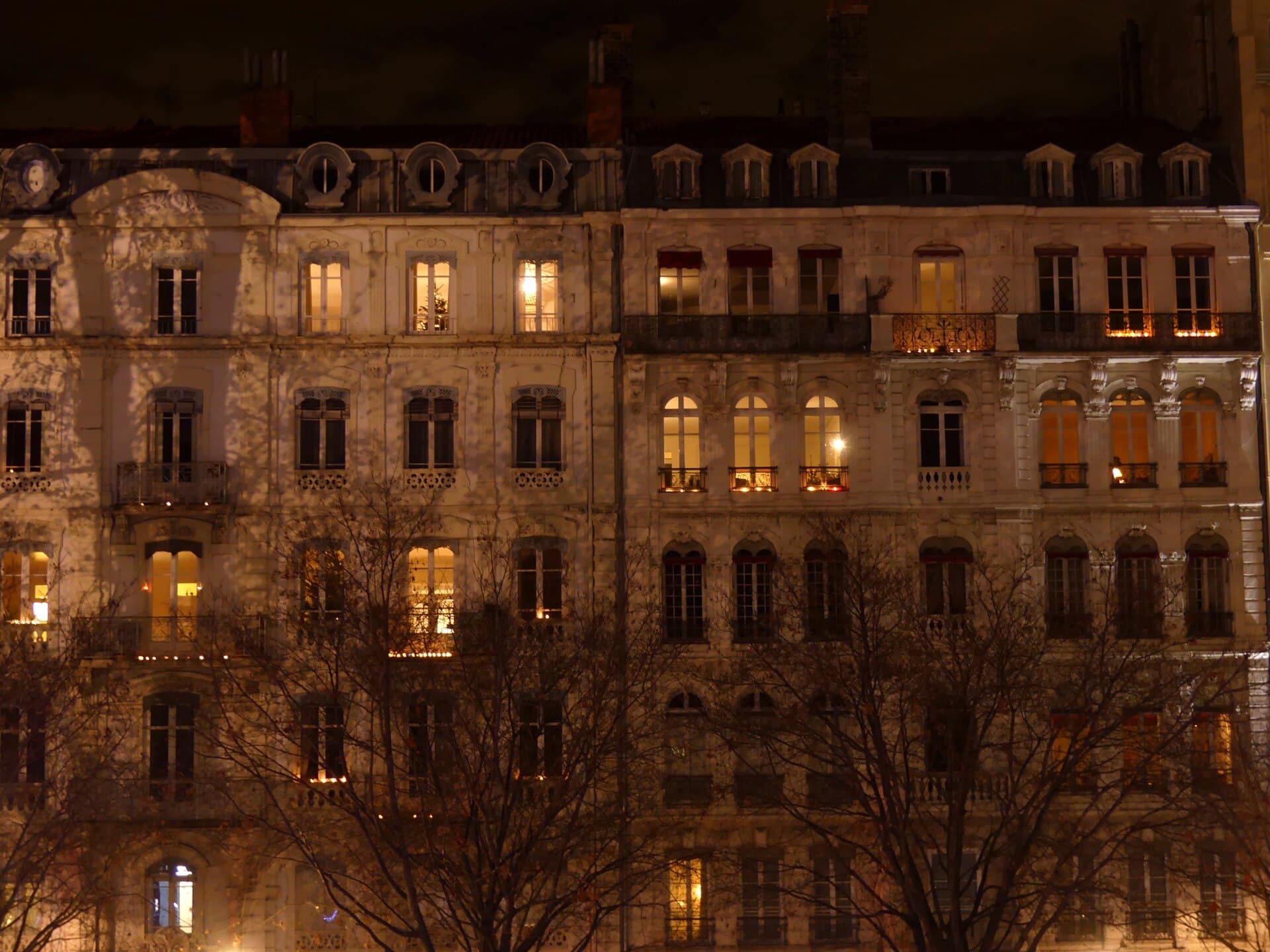 Candles in coloured glass lumignons on a windowsill in Vieux-Lyon on 8 December