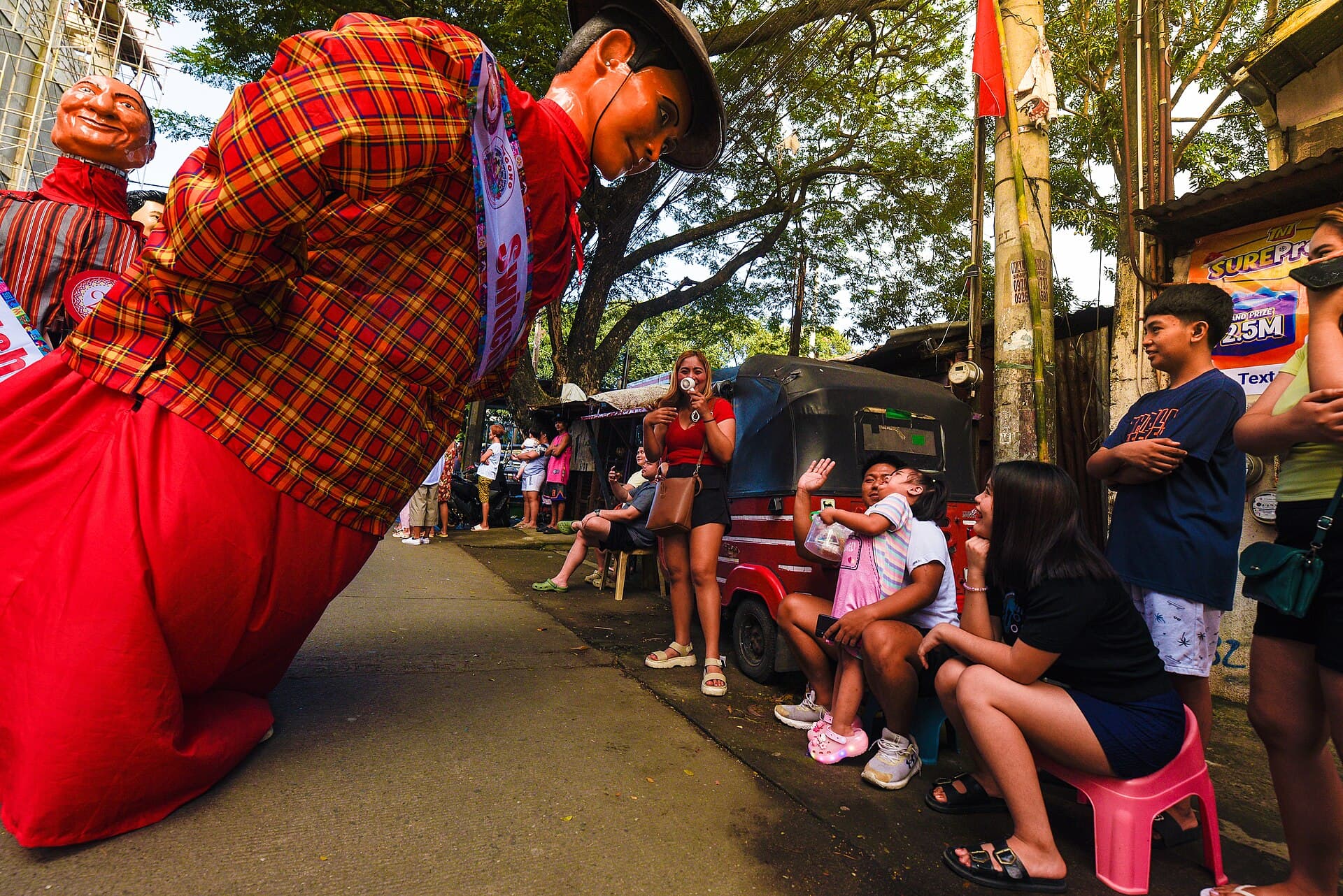 Parehadoras in colourful costumes and wooden slippers carrying sagwan paddles in Angono