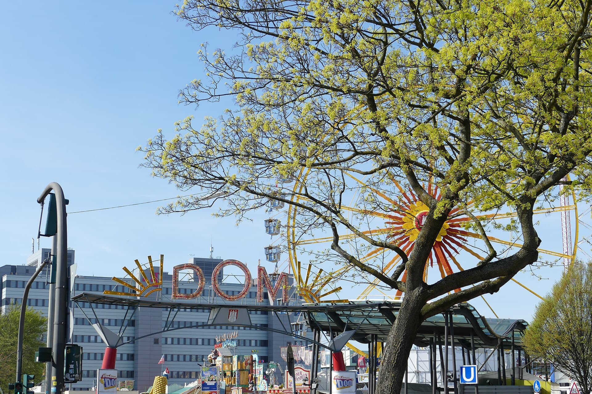 Visitors walking through an open entrance onto the Heiligengeistfeld fairground in the evening