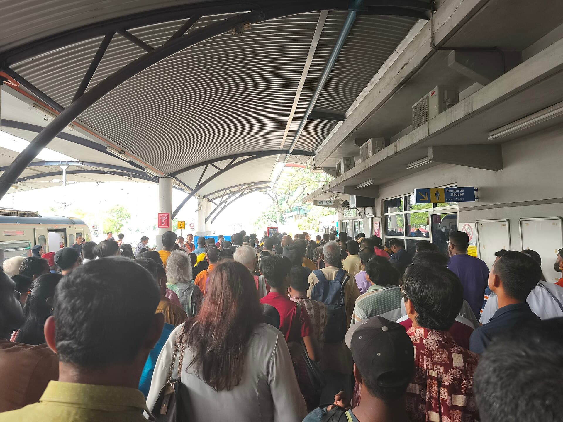 Crowded platform at Batu Caves KTM Komuter station with devotees carrying milk pots