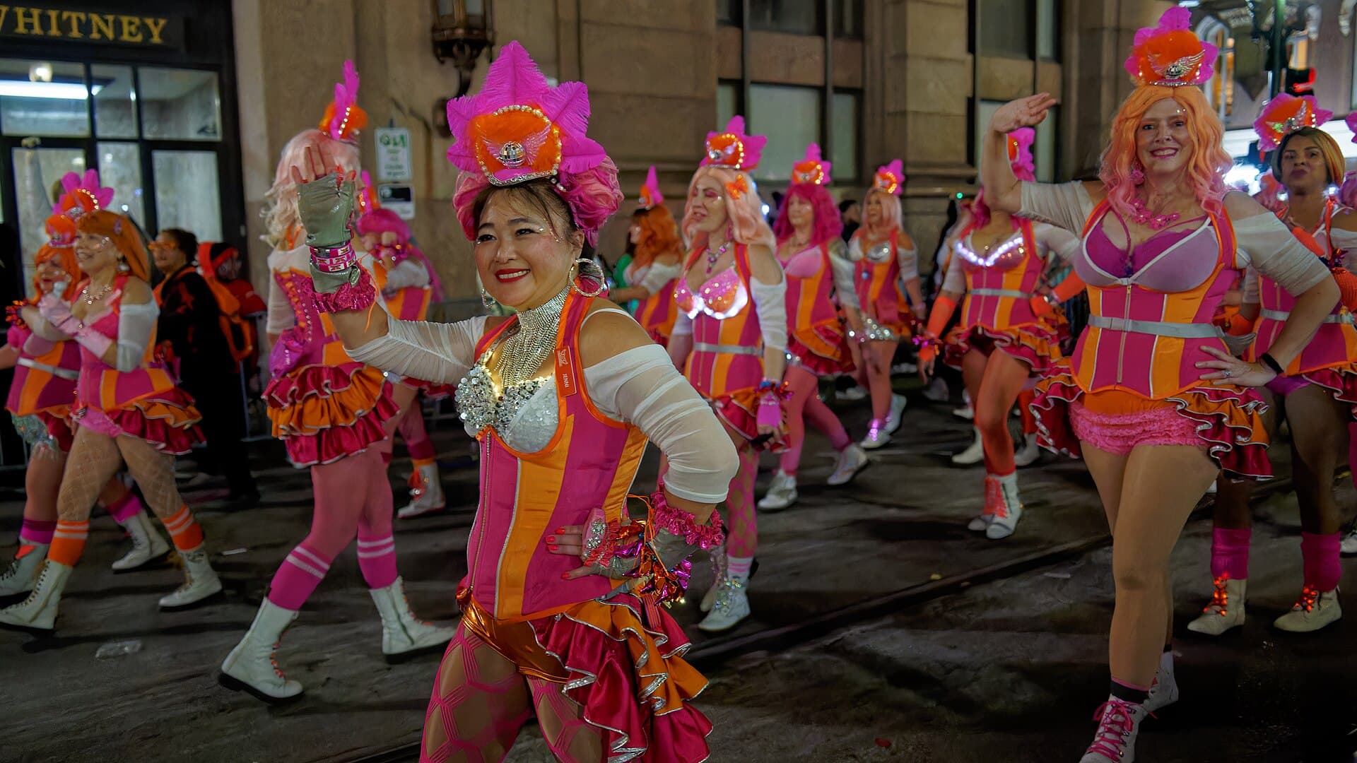 Krewe of Muses rider holding up a glittered hand-decorated shoe during the Thursday night parade
