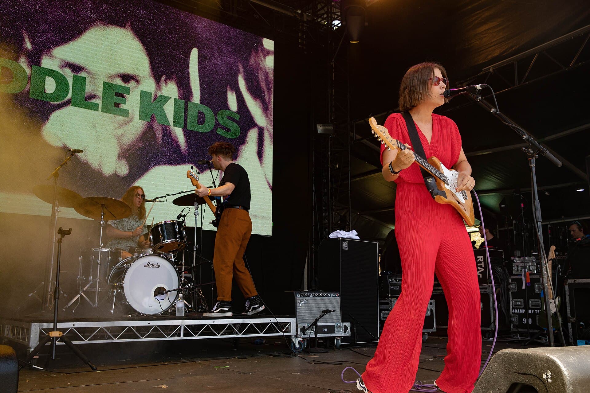 Fontaines D.C. performing live on an outdoor festival stage under coloured lights