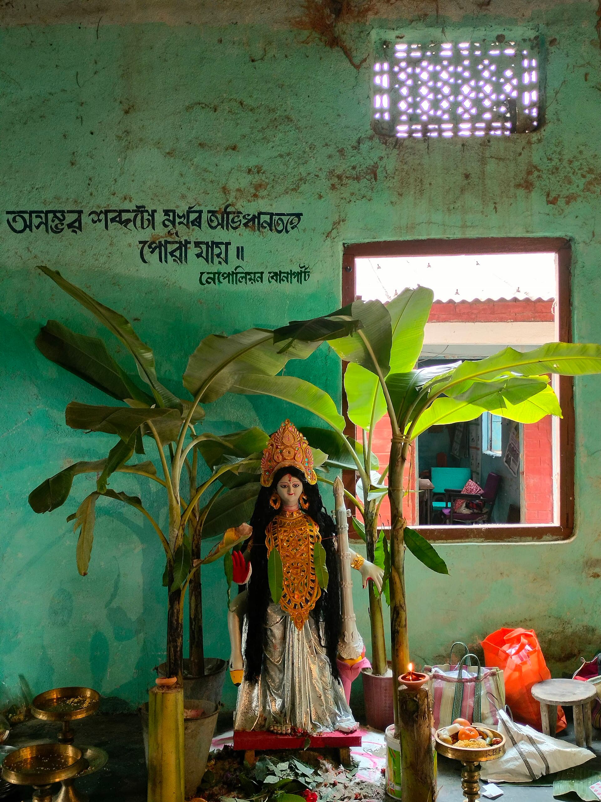 A small neighbourhood Saraswati Puja marquee in a north Kolkata lane with a white clay goddess on a swan