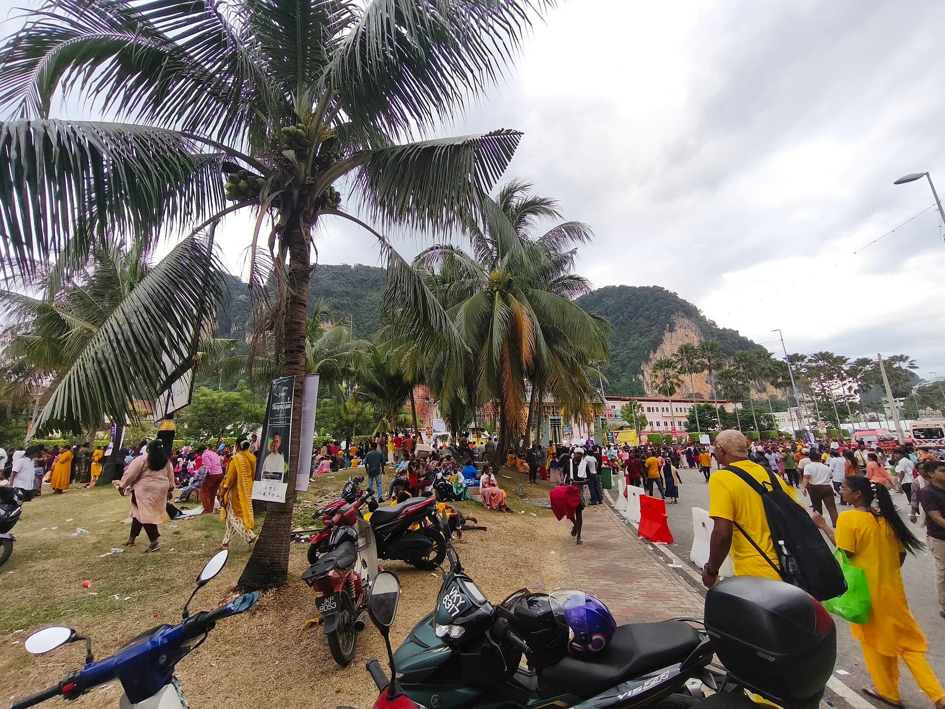 Rows of stalls selling flowers, coconuts and prayer items on the road beside the Batu Caves complex