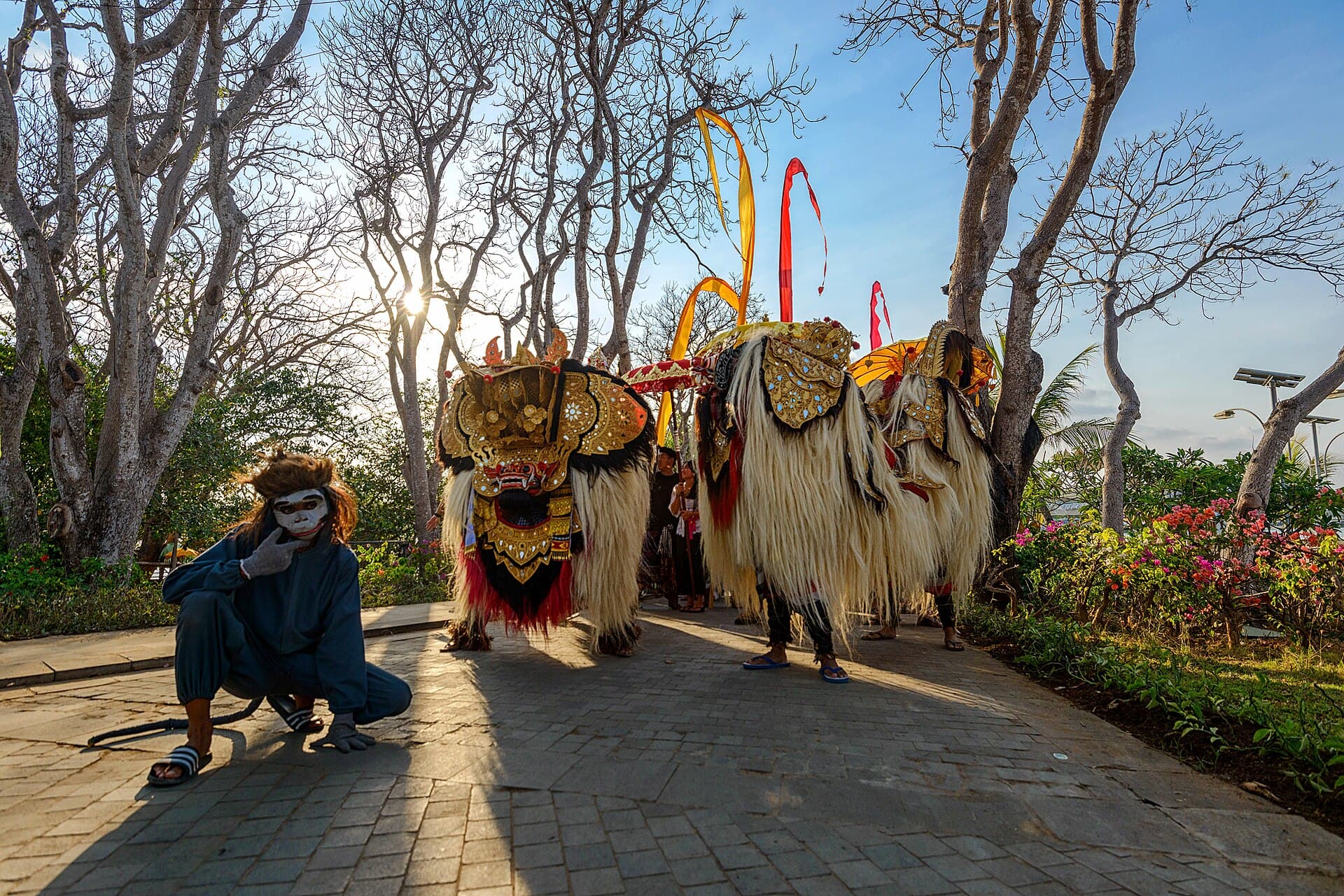 Children performing the Barong Bangkung ngelawang dance in a Bali village lane with gamelan players