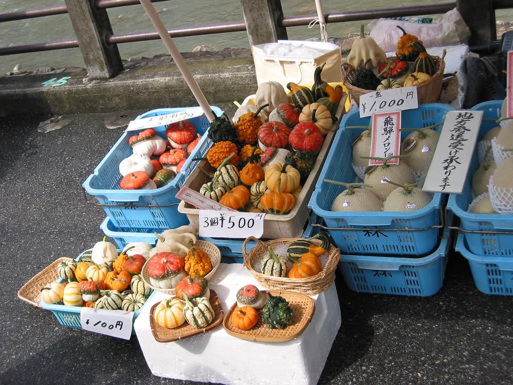 A stall in the Sanmachi old town grilling skewers of Hida beef beside a sake brewery with a cedar ball over the door