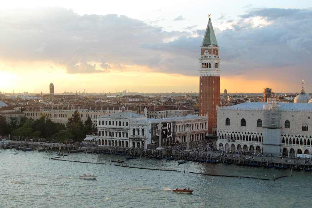 Crowd of masked visitors filling Piazza San Marco under the Campanile on a carnival afternoon