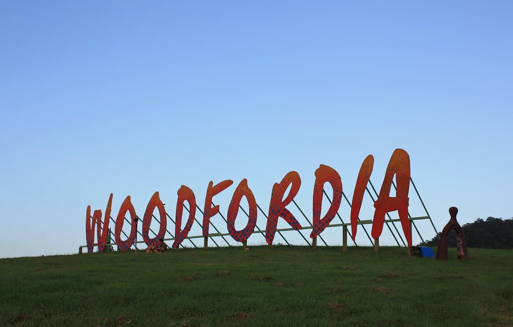 The Woodfordia entrance and festival village in late afternoon light with crowds arriving