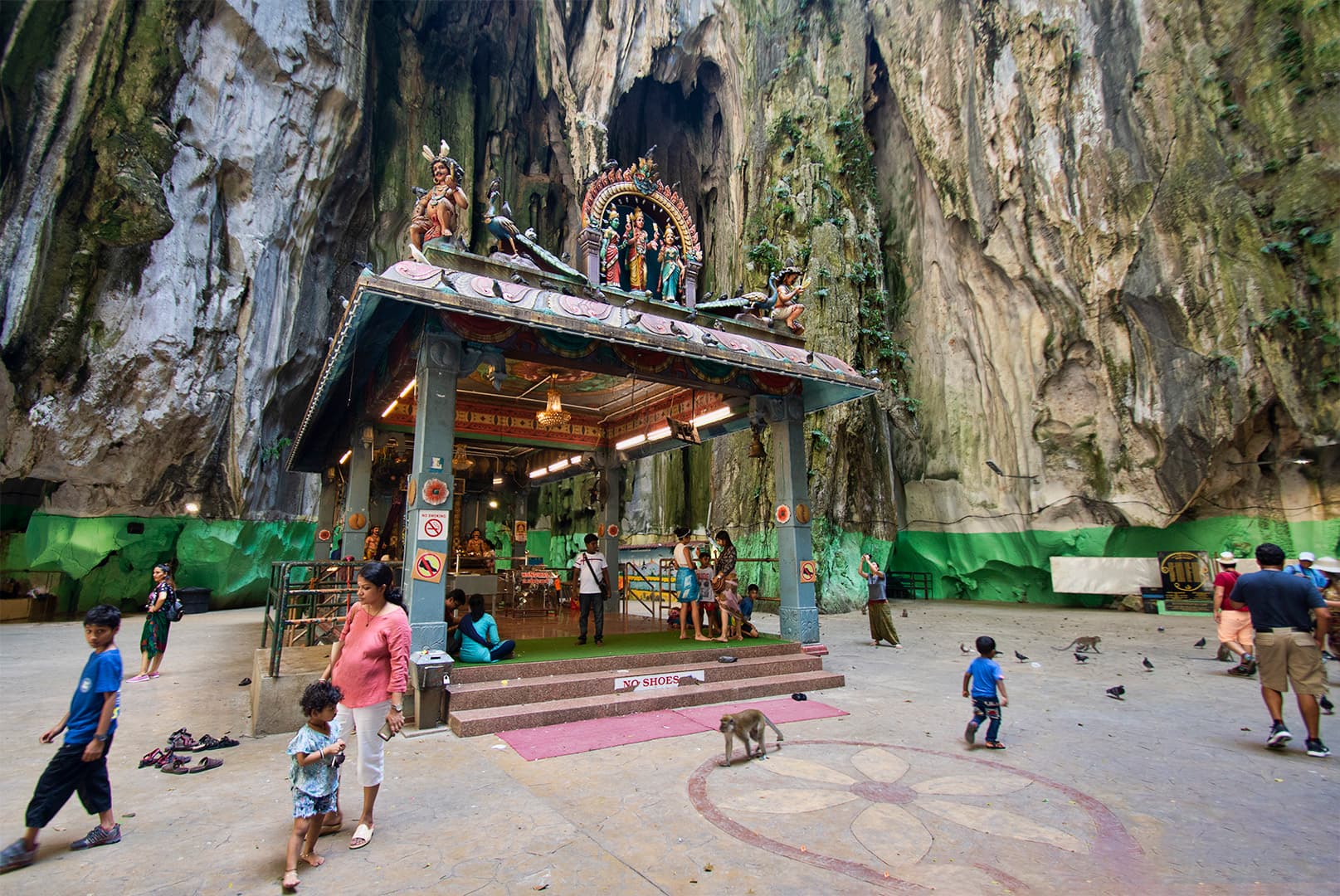 Heavy cloud building over the limestone hill at Batu Caves with crowds on the steps