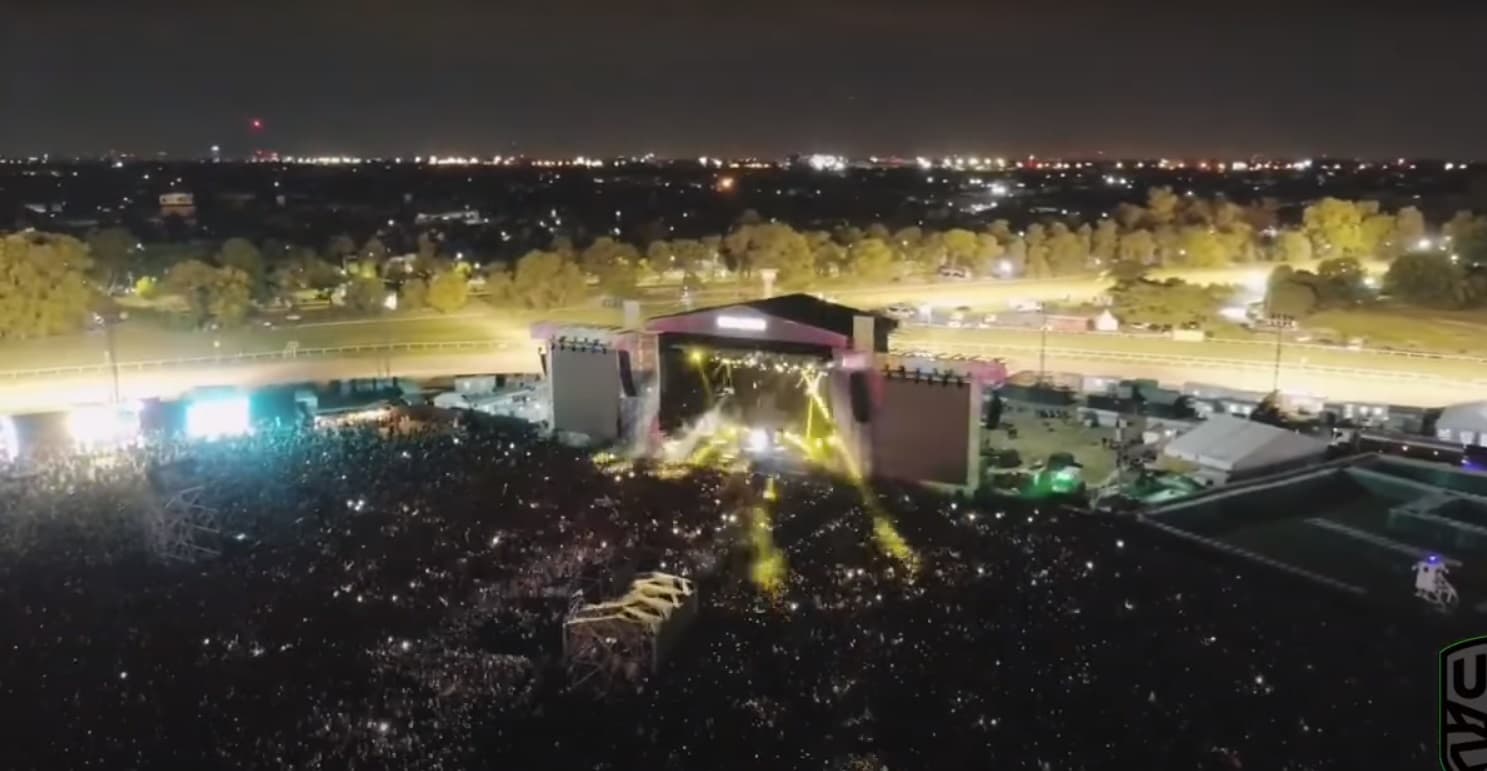 Evening view of the main stages and screens at Lollapalooza Argentina with the racetrack grandstand behind