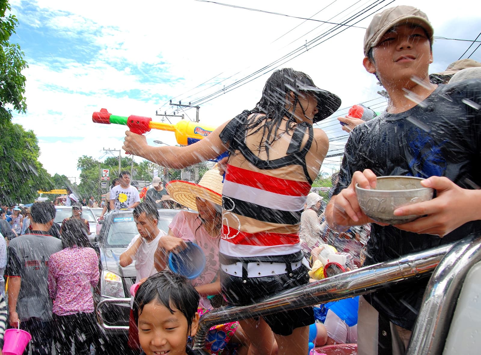 Wide view of Tha Phae Gate in Chiang Mai packed with people splashing water during Songkran, landscape
