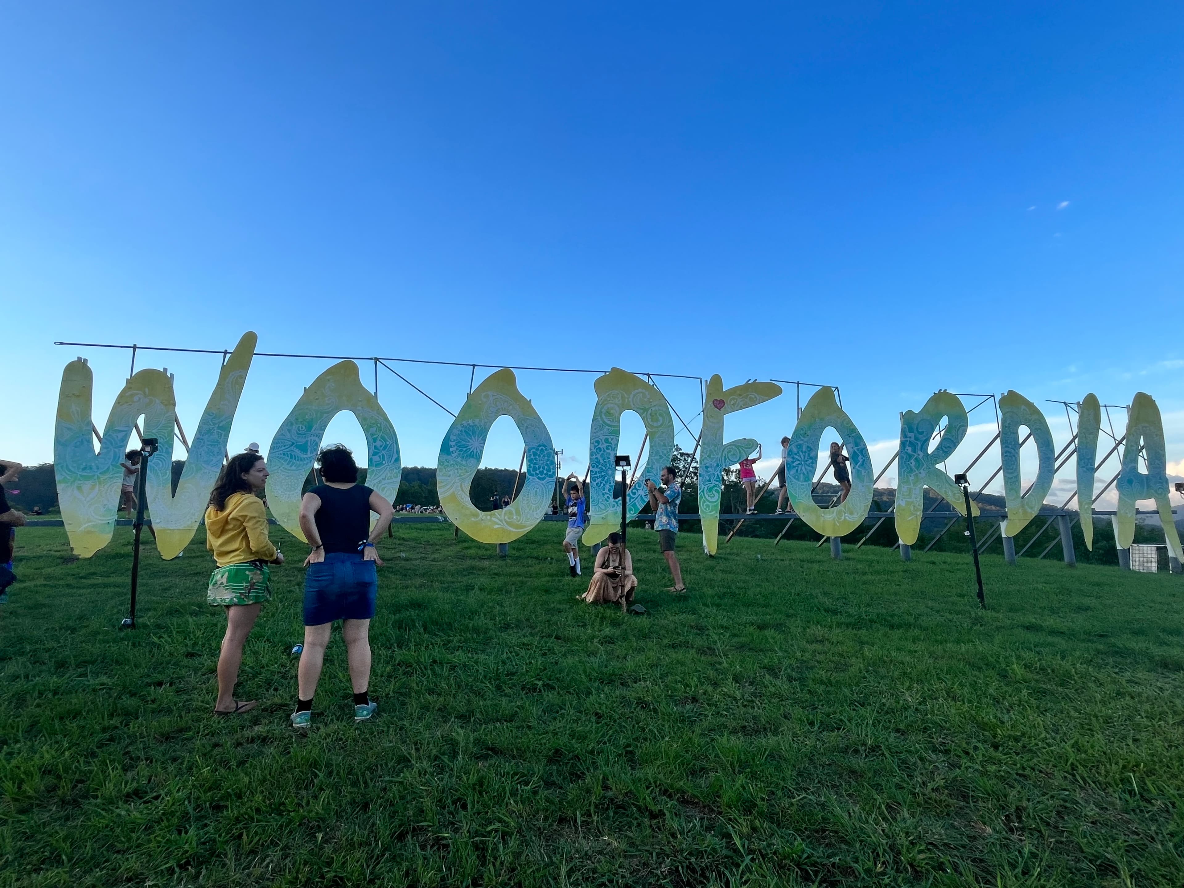 Coaches parked at the Eastern Bloc Transit Lounge beside Woodfordia, with festival-goers lifting luggage