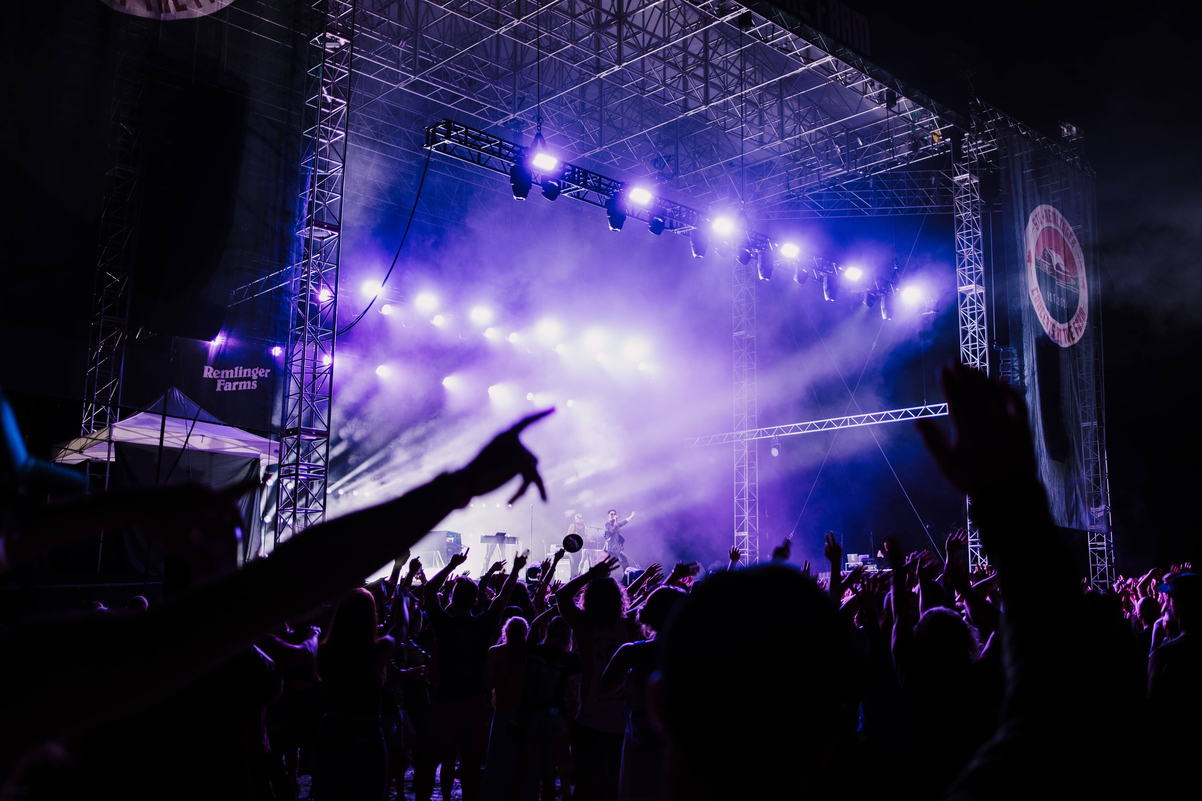 The Green Stage at Fuji Rock Festival seen from the crowd on the grassy slope at Naeba, with forested mountains behind