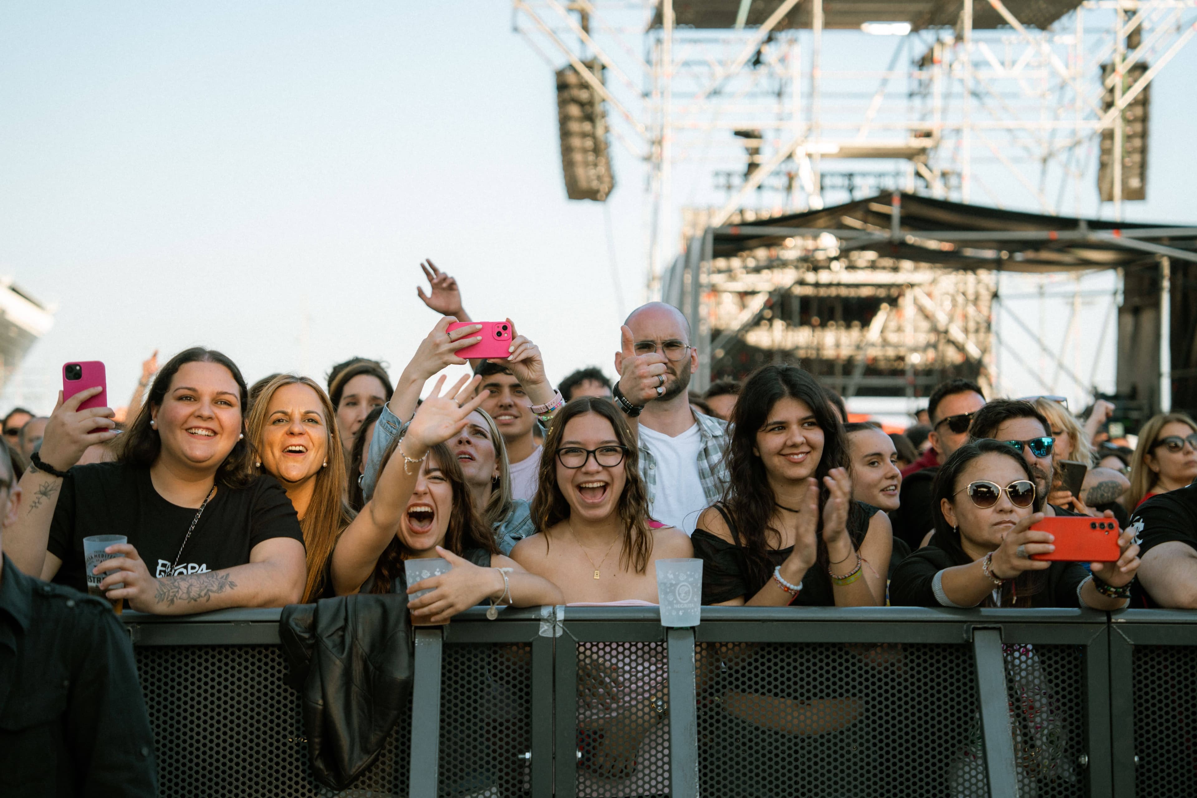 Festival crowd at dusk at Corona Capital wearing jackets as the sun sets over the Autódromo in Mexico City
